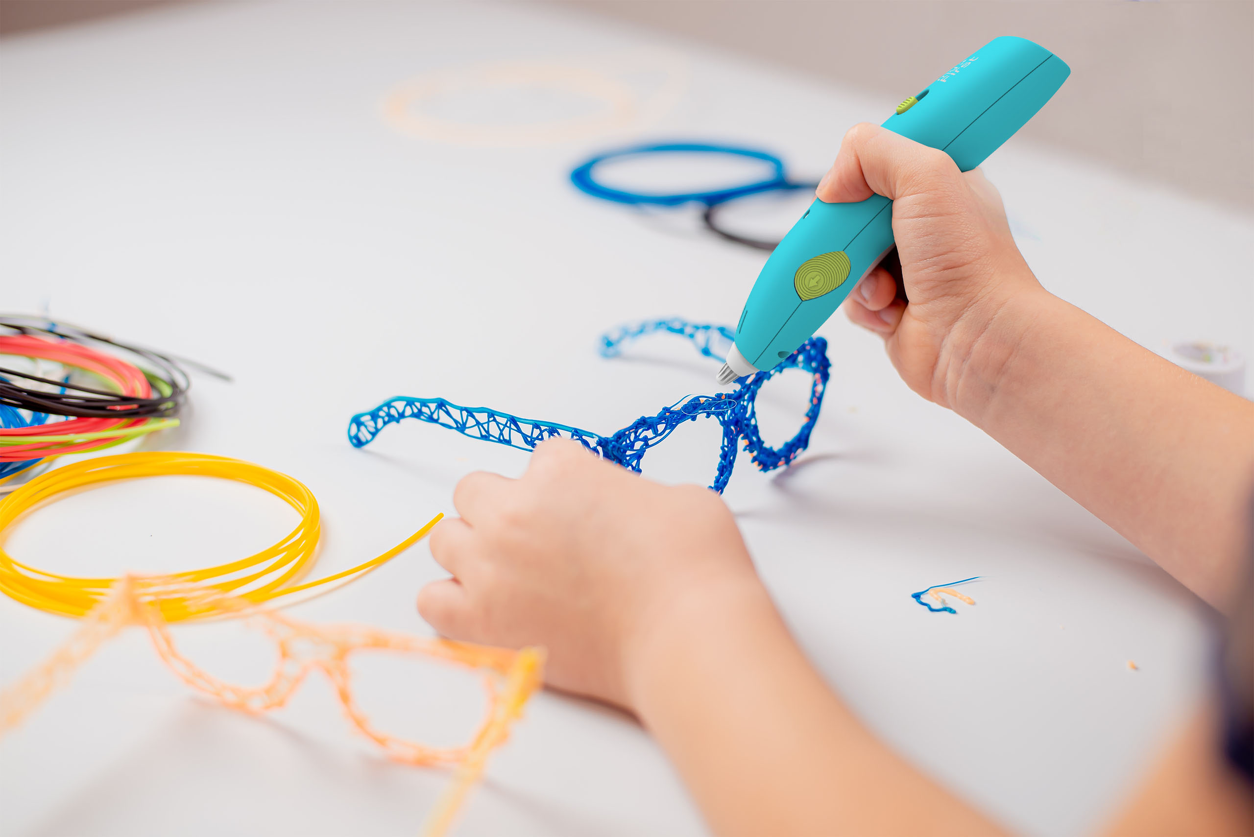 Focused child with 3d printing pen creating a toy